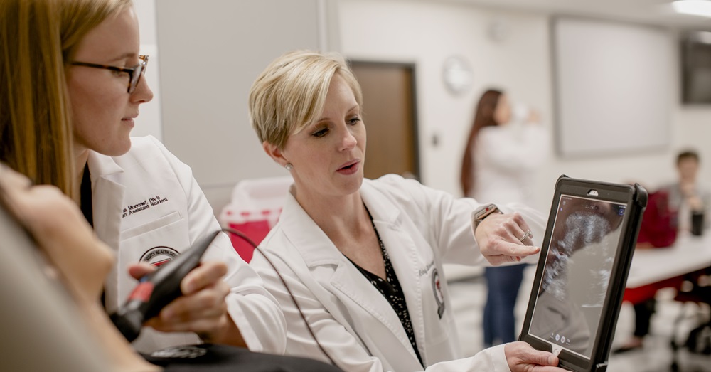 women in lab coats looking at an ultrasound