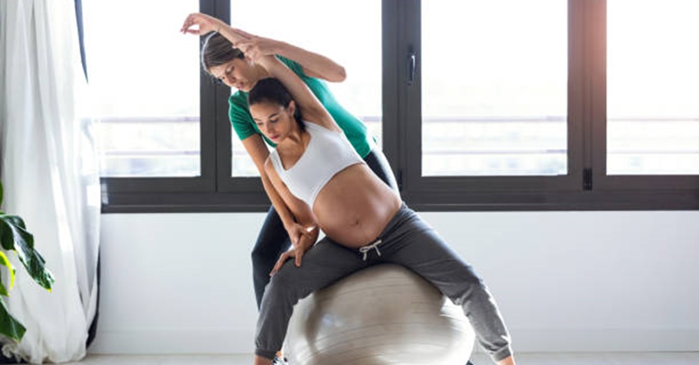 pregnant woman exercises with a physical therapist