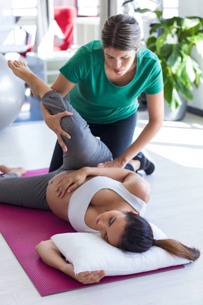pregnant woman exercises with a physical therapist