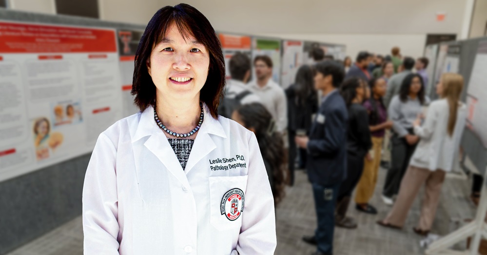 Student Leslie Shen, Ph.D., stands in front of posters at student research week