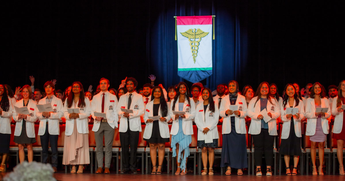 TTUHSC medical students wear their white coats and recite an oath on stage.