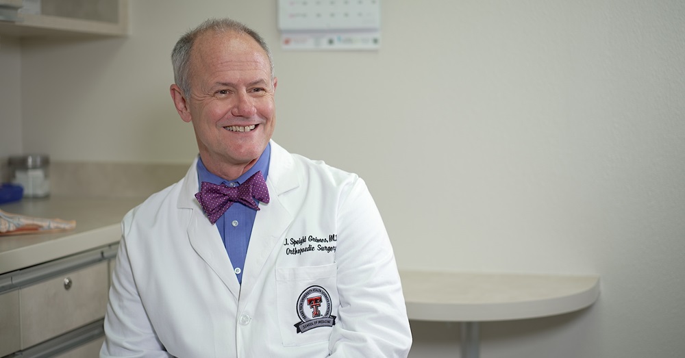 Jerry Grimes, M.D. smiling in a white coat