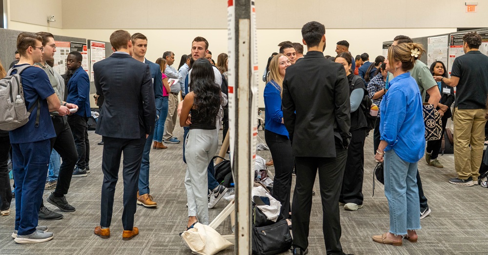 students stand and converse at an event