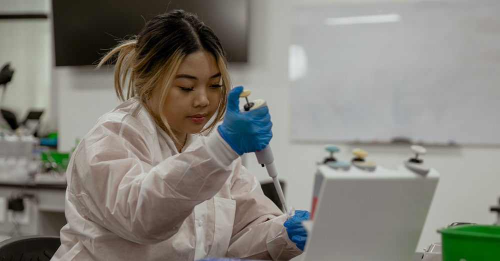 woman in a lab setting handling molecular testing tools