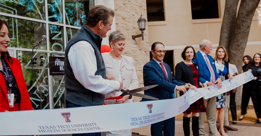 TTUHSC leadership standing behind a large ribbon outside of the TTUHSC Dallas campus building