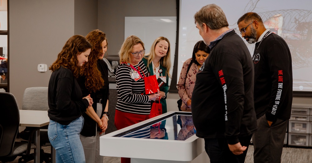 people standing around an anatomage table (interactive screen for anatomy) at the new Dallas TTUHSC campus