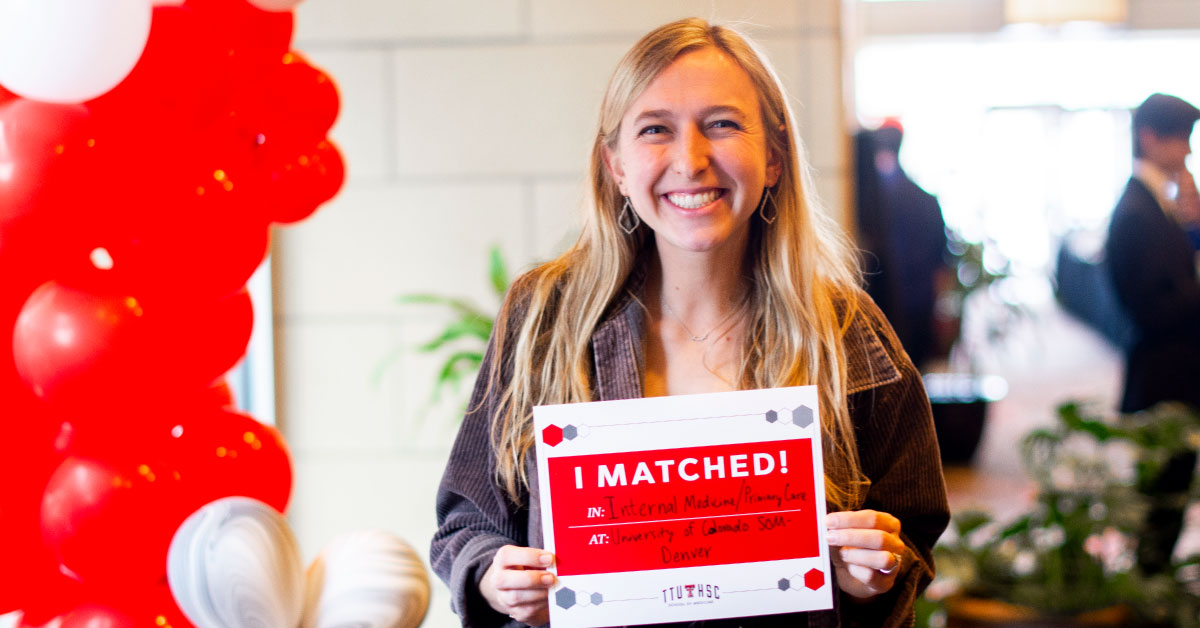 Female TTUHSC medical student holds up a sign showing where she matched.