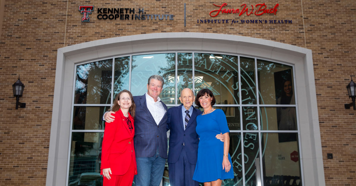 Four people stand in front of glass door with a Kenneth H. Cooper Institute sign above.