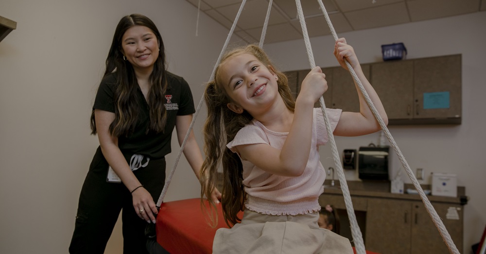 health care professional and young girl on swing