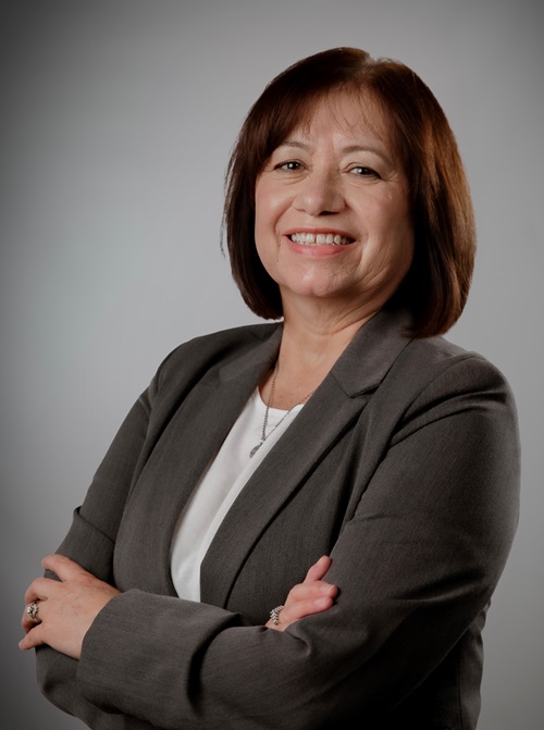 woman standing for a headshot with a studio backdrop