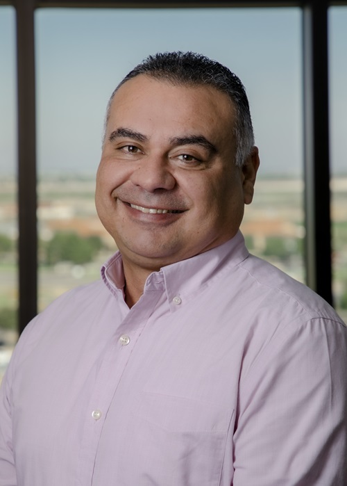 man standing for headshot with window backdrop