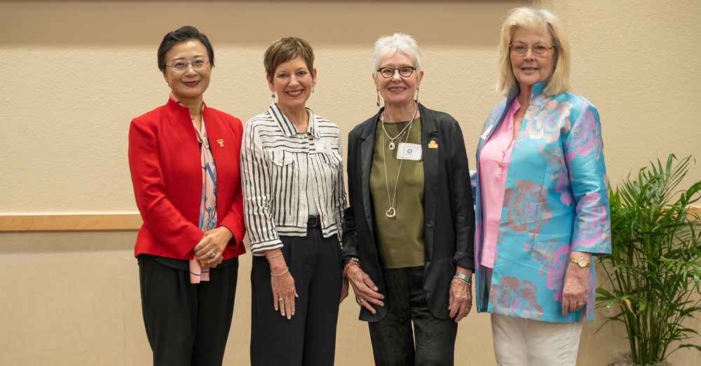 four women stand in a row for a group photo