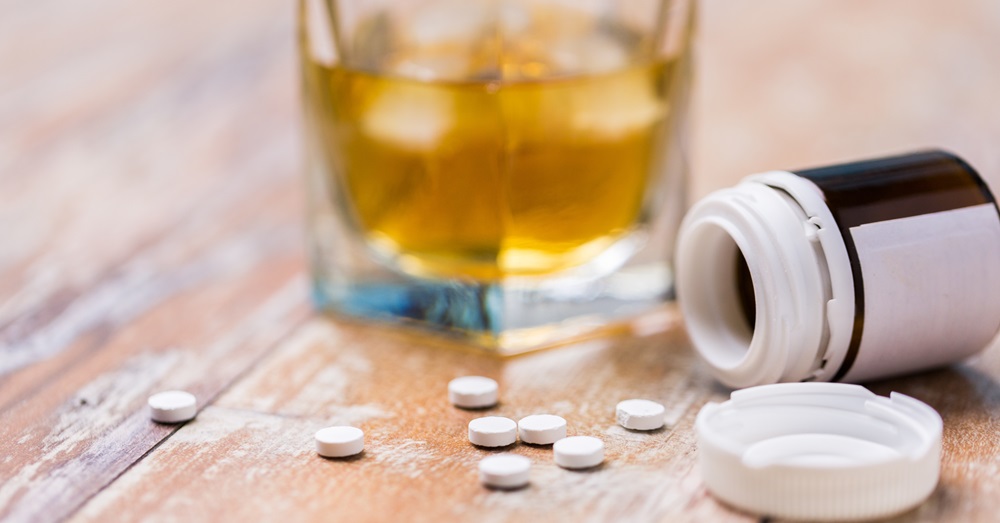 image of alcoholic drink and pills on a table